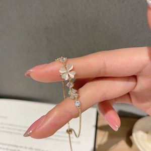 Detail of elegant gold bracelet featuring cat eye stone petals and sparkling zircon accents