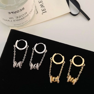 Detail of silver and gold double chain hoop earrings with micro-pave spiral pendants