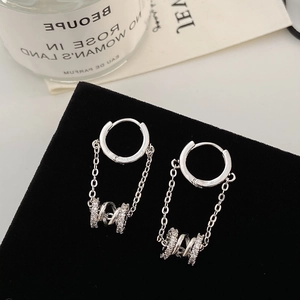 Detail of silver drop earrings with pavé double rings on a black velvet display stand