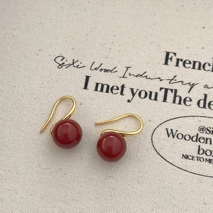 Gros plan d'élégantes boucles d'oreilles en perles rouges avec crochets dorés