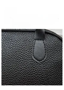 Macro shot of high-quality black litchi pattern leather with detailed stitching