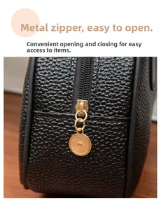 Detail of lychee pattern leather bag showing the smooth metal zipper and ring puller