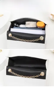 Vue intérieure d'un sac à chaîne bicolore spacieux avec cosmétiques et téléphone