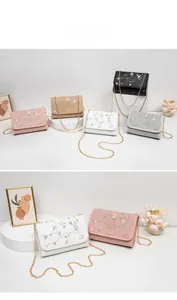 Détail de la broderie florale et de la chaîne dorée sur ce sac bandoulière élégant