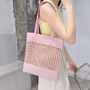 Pink hand-woven crochet tote bag with hollow diamond pattern and long leather handles