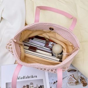 Pink woven tote bag with leather handles and yellow lining showing large inner capacity