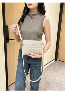 Détail du sac bandoulière en paille tressée avec motif chevron et boucle dorée