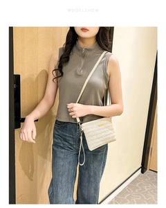 Mannequin portant un sac bandoulière beige tissé avec logo en métal et bandoulière