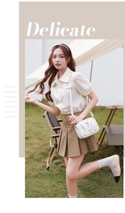 Detailed floral embroidery on a white crossbody camera bag styled for outdoor casual wear