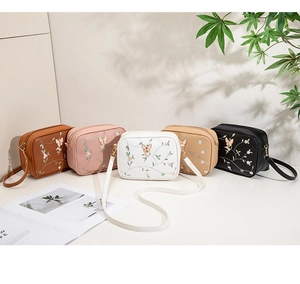 Five assorted crossbody bags featuring butterfly and floral embroidery in diverse colors