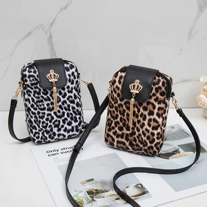 Chic leopard print crossbody shoulder bags with tassels and gold crown detail on marble