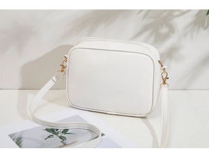 Minimalist white rectangular crossbody bag with golden zipper and smooth leather texture