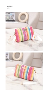 Détail du sac tissé arc-en-ciel avec bandoulière blanche et finitions dorées