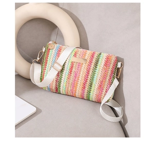 Détail d'un sac bandoulière tissé arc-en-ciel avec sangle blanche et boucles dorées