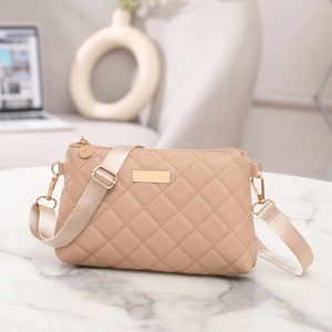 Close-up of the quilted faux leather texture and gold hardware on a beige crossbody bag