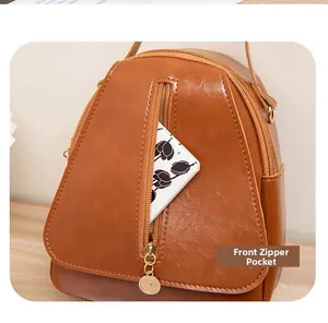 Détail de la poche zippée avant sur un sac bandoulière en cuir PU marron avec accents dorés