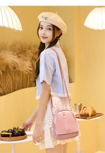 Detail view of a light pink mini backpack with vertical zippers and matte leather texture