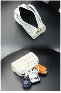 Detail view of white Boston bag interior capacity showing phone, umbrella and cosmetics
