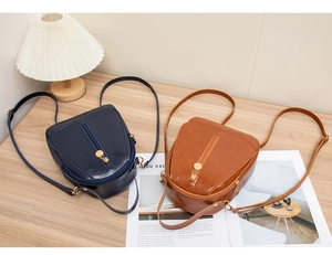 Mini PU leather backpacks in blue and brown with golden hardware on a wooden table