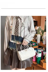Close-up of white boston bag with yellow polka dots and golden butterfly hardware