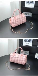 Detailed view of pink barrel bag with floral print and butterfly gold hardware