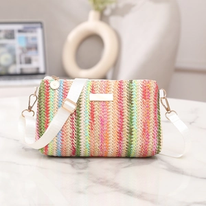 Colorful striped woven crossbody bag with white nylon strap on marble surface