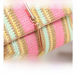 Close-up of colorful woven straw bag with gold tassel hardware and precise texture