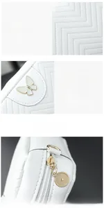 Detail of white quilted camera bag with gold butterfly metal hardware and ring zipper