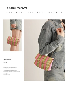 Detail of woven rainbow crossbody bag with gold buckle and chain shoulder strap