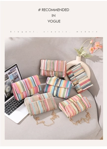 Handwoven rainbow crossbody bags with gold chains on a cozy grey sofa setting