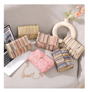 Detail of woven straw crossbody bags with rainbow stripes and golden T-bar metal clasp