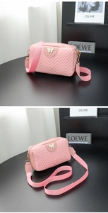 Detailed close-up of pink chevron quilted camera bag with butterfly metal hardware