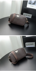 Detailed macro view of the chevron stitching and golden butterfly charm on a brown camera bag