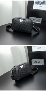 Detail of black chevron quilted camera bag with white butterfly motif and wide strap