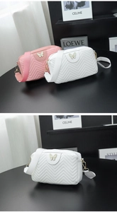 Macro view of camera bag with quilted chevron texture and gold butterfly clasp detail