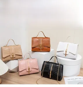 Detail display of croc-embossed handbags in five colors with metallic tassels and chain strap
