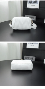 Close-up of white chevron quilted camera bag with wide strap and gold hardware accents