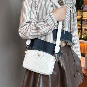 White quilted camera bag with golden butterfly buckle and wide adjustable fabric strap