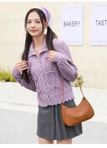 Detail showing lavender knit cardigan with 3D ribbon bows and classic cable stitch texture