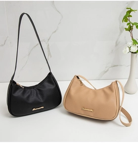 Detailed view of two lychee pattern hobo bags in black and beige on marble background