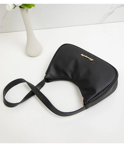 Close-up of black lychee grain leather underarm bag with gold logo and metallic zipper