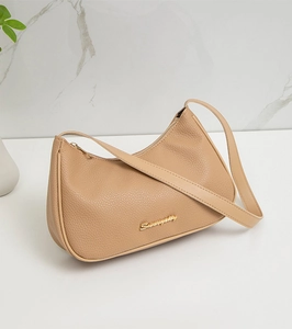 Detailed view of beige lychee grain leather underarm bag with gold metal logo
