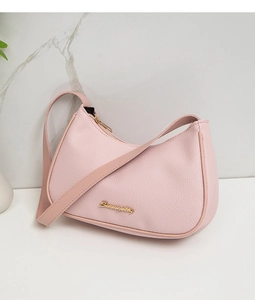 Close-up of pink hobo bag with soft litchi texture and elegant gold logo detail