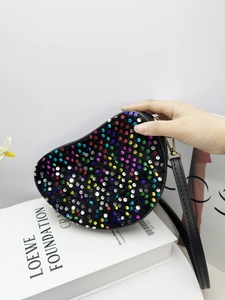 Makroaufnahme der Glitzerpailletten und des Reißverschlusses der schwarzen Umhängetasche