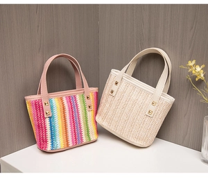 Close-up of woven straw tote bags with gold studs in rainbow and natural beige colors