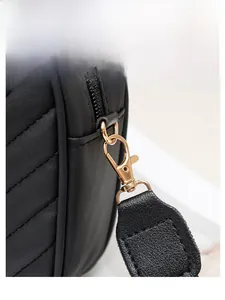 Detailaufnahme des hochwertigen Goldkarabiners und der gesteppten schwarzen Ledertasche
