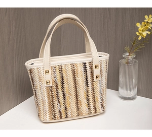 Detail of hand-woven straw tote with colorful stripes and faux leather handles