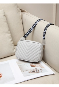 Detailansicht der beigen Stepptasche mit V-Muster und breitem Marken-Schultergurt