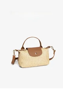 Detail of woven straw handbag with brown leather flap and metallic buckle on white background
