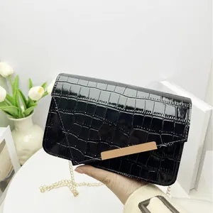 Black crocodile embossed patent leather crossbody bag with elegant gold chain strap